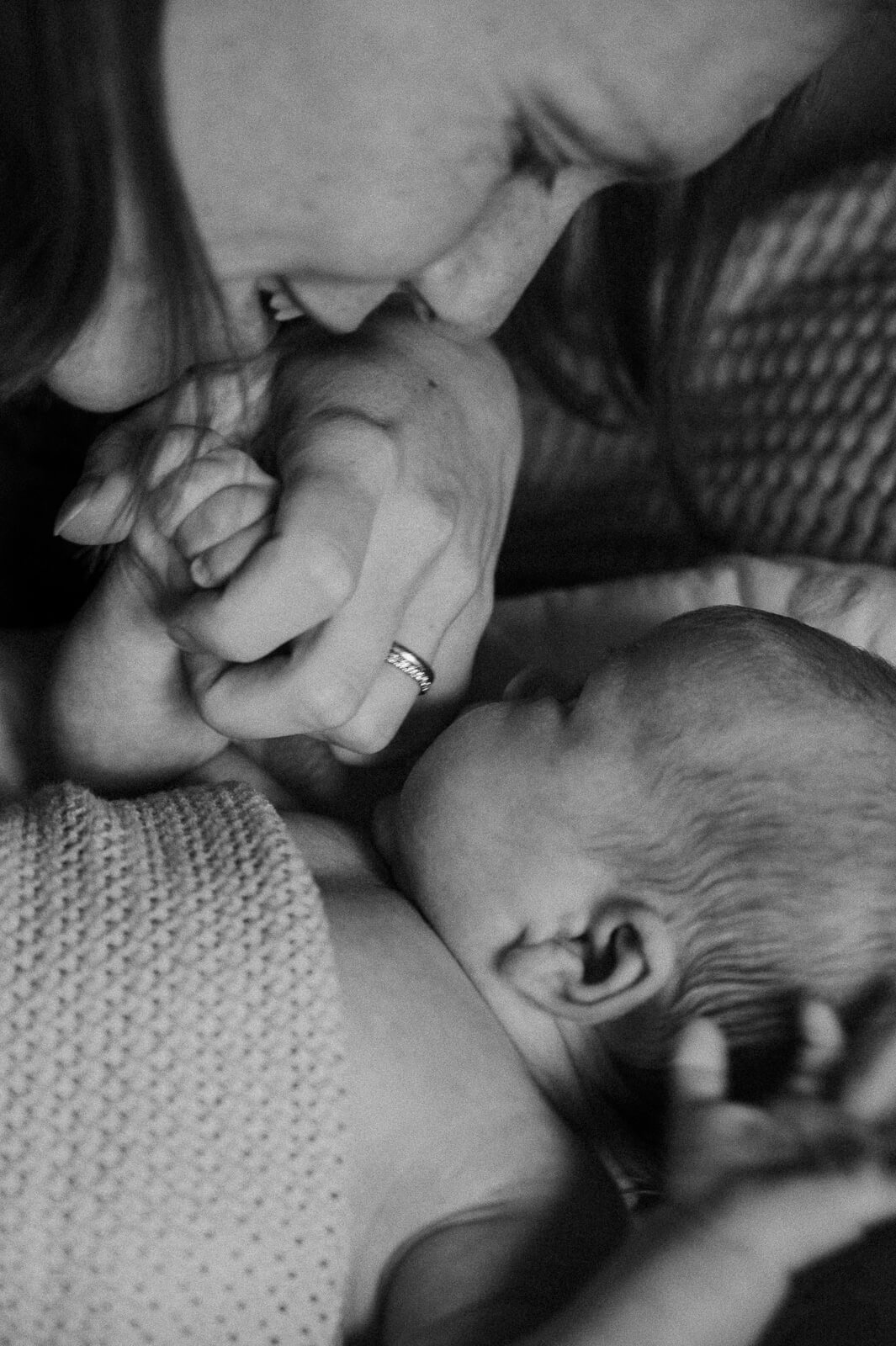 Schwarzweissbild von einer Mutter, die die Hand ihres Baby hält von Babyfotografin aus Zürich