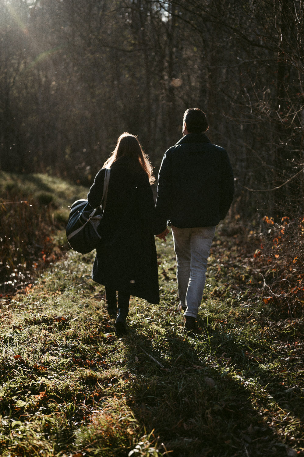 Paar, das Hand in Hand auf einer Wiese läuft von einer Paarfotografin aus Zürich