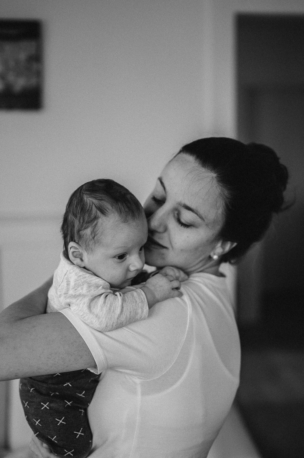 Schwarzweissbild von einer Mutter, die ihr Baby in den Armen hält von Babyfotografin aus Zürich