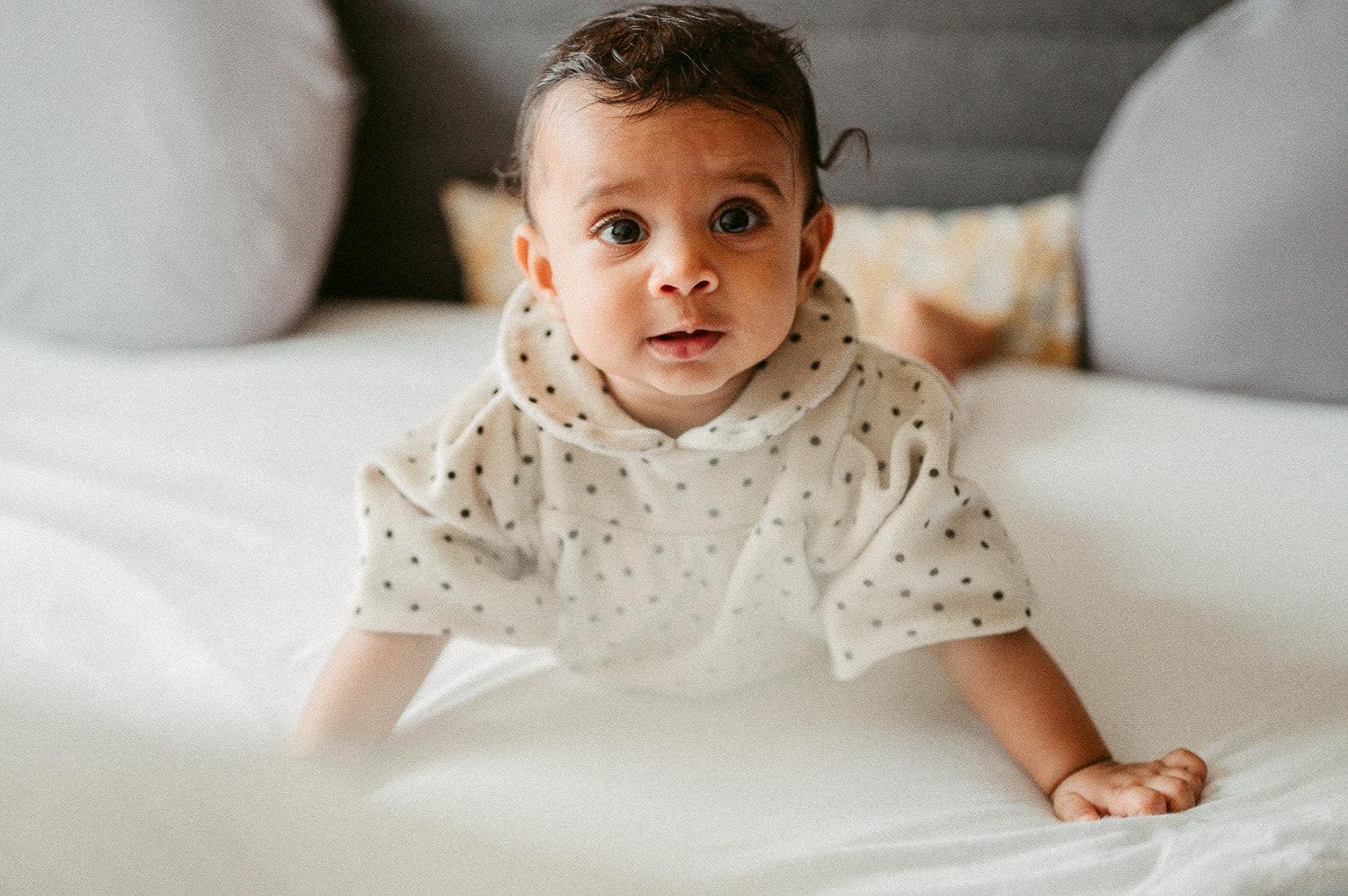 Fotografie eines Babys in schwarzweiss gepunktetem Kleid von Babyfotografin aus Zürich